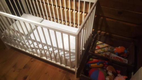 a white crib with toys in it at Large family cabin in Hafjell ski in-out, BBQ, terrace and fireplace in Hafjell