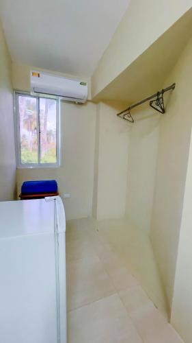 a white room with a window and a blue chair at Hotel Turístico Marian in Las Terrenas