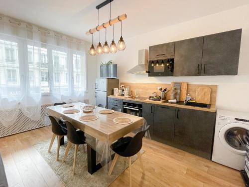 une cuisine avec une table en bois et une salle à manger dans l'établissement Le Masséna - Lyon 6ème - Proche Parc Tête d'Or, à Lyon