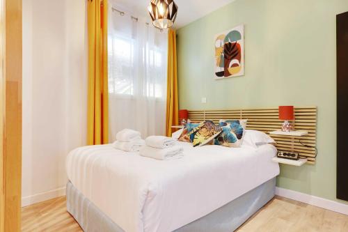 une chambre avec un lit avec des draps blancs et une fenêtre dans l'établissement Charming apartment with AC -1BR-3P- Sentier, à Paris