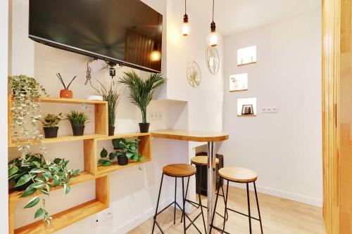 une cuisine avec un bar avec des tabourets et des plantes dans l'établissement Charming apartment with AC -1BR-3P- Sentier, à Paris