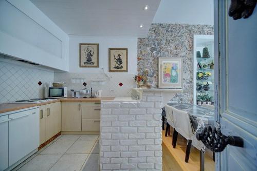 une cuisine avec une table et un mur en briques dans l'établissement A2B159 - APPARTEMENT ATYPIQUE au SUQUET AVEC 2 CHAMBRES!!, à Cannes