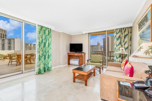 a living room with a couch and a tv at Luana Waikiki Hotel & Suites in Honolulu