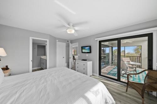 a bedroom with a bed and a sliding glass door at Sandpiper Beach 101 in Sanibel