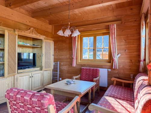 a living room with a table and chairs and a tv at 1A Chalet Koralpenglück Wandern, Grillen und Indoor Sauna in Elsenbrunn