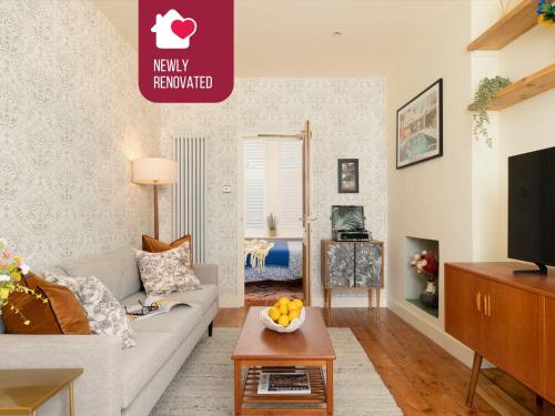 a living room with a couch and a tv at The Lorelei Chic Urban Retreat with Terrace in Brighton in Brighton & Hove