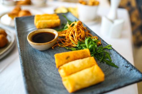 a black plate with some food on a table at Hotel Monogram Park in Ruma