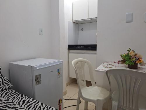 una cucina con tavolo, sedie e frigorifero di Linda Kitnet Mobiliada 03 a Salvador