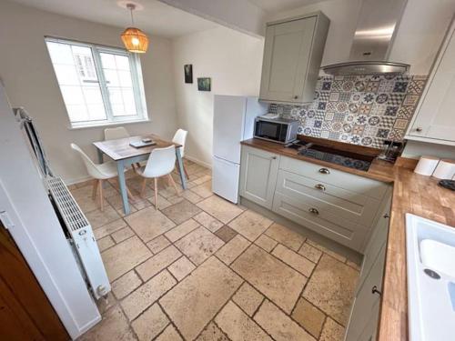 a kitchen with a table and a dining room at Cosy Cottage in Medieval Conwy with garden and parking in Conwy