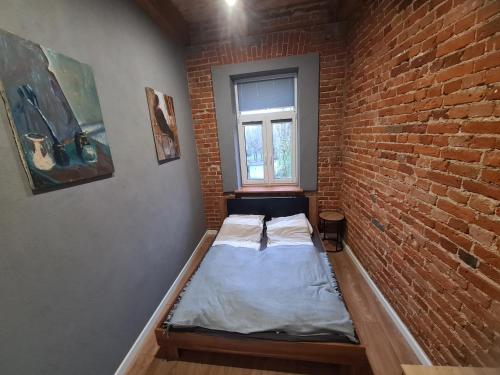 a small room with a bed in a brick wall at Apartament w Kamienicy 13 in Siedlce