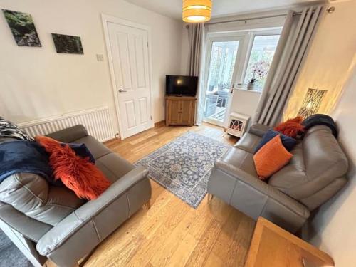 a living room with two couches and a television at Cosy Cottage in Medieval Conwy with garden and parking in Conwy