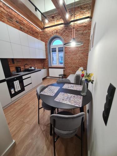 a kitchen and dining room with a table and chairs at Apartament w Kamienicy 13 in Siedlce