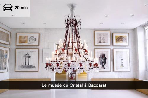 a large chandelier in a room with pictures at Appartement, Nature, Relaxation et Demi-Pension Possible in Crévic