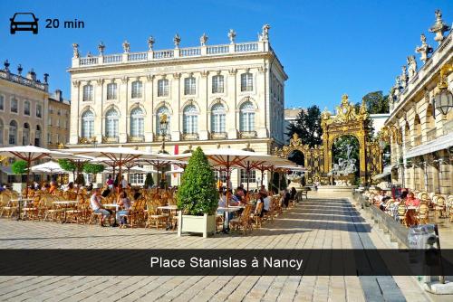 a group of people sitting at tables in front of a building at Appartement, Nature, Relaxation et Demi-Pension Possible in Crévic