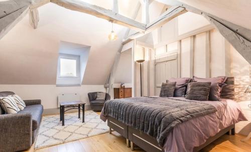 a bedroom with a large bed and a chair at Villa du Vieux Château in Les Andelys