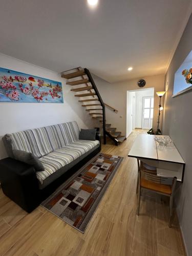 a living room with a couch and a table at Duplex Moderno Perto da Praia in Armação de Pêra