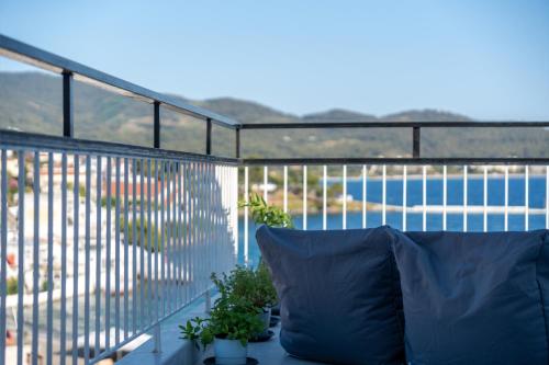 a blue pillow sitting on a balcony with a view at Mikelanna Aegean Skyline in Neos Marmaras