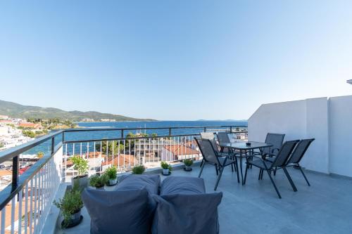 a patio with a table and chairs on a balcony at Mikelanna Aegean Skyline in Neos Marmaras