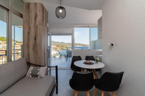 a living room with a couch and a table with chairs at Mikelanna Aegean Skyline in Neos Marmaras