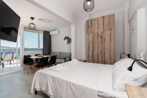 a bedroom with a white bed and a table and chairs at Mikelanna Aegean Skyline in Neos Marmaras