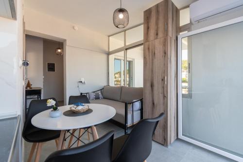 a living room with a table and chairs and a couch at Mikelanna Aegean Skyline in Neos Marmaras
