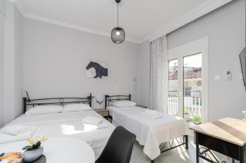 two beds in a room with a table and chairs at Mikelanna Aegean Skyline in Neos Marmaras