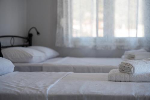 a bedroom with two beds with towels on them at Mikelanna Aegean Skyline in Neos Marmaras