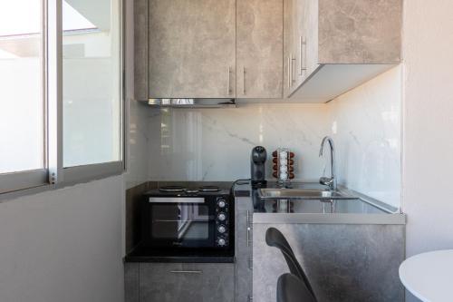 a small kitchen with a sink and a stove at Mikelanna Aegean Skyline in Neos Marmaras