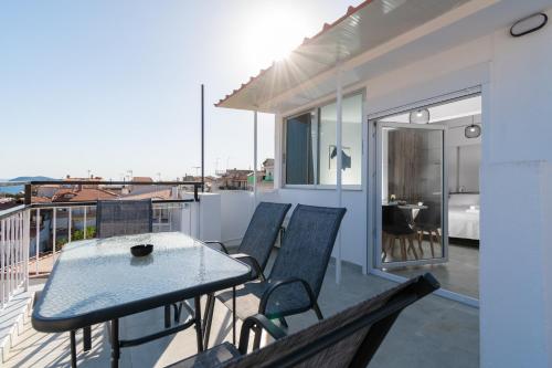 a patio with a table and chairs on a balcony at Mikelanna Aegean Skyline in Neos Marmaras