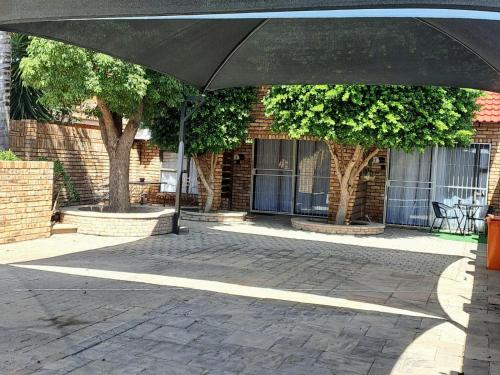 a black umbrella in front of a brick building at Hillcrest Hosting AirBnB in Kimberley