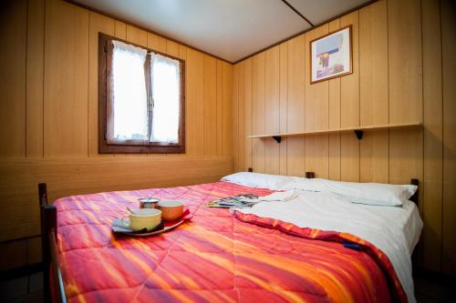 a bedroom with a bed with a plate of food on it at Villaggio Turistico Camping Cervino in Antey-Saint-André
