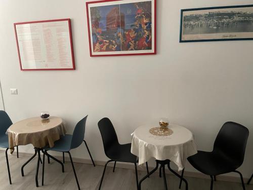 two tables in a room with chairs and a painting at La Presentosa Bed&Breakfast in Ortona