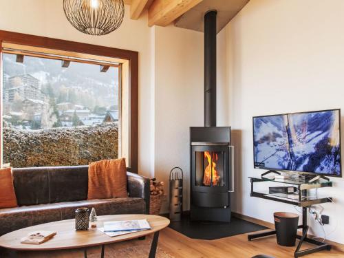a living room with a couch and a fireplace at Chalet Beke by Interhome in Nendaz