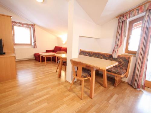a living room with a couch and a table at Apartment Voithofer-4 by Interhome in Königsleiten