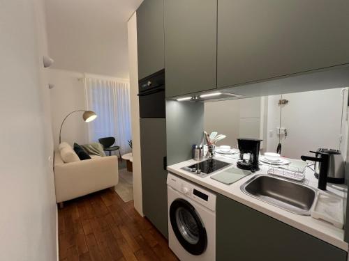 une cuisine avec un évier et une cuisinière four supérieur dans l'établissement Appartement de Standing - Place des Vosges - Cozy 2 pieces - une chambre, à Paris