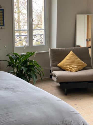 - une chambre avec un canapé et un oreiller jaune dans l'établissement La Maison de l'Andelot, à Monteignet-sur-lʼAndelot