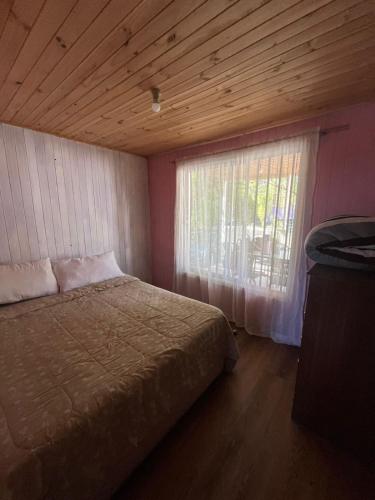 a bedroom with a large bed and a window at Cabañas Vega de Ancoa in Cruce Ancoa