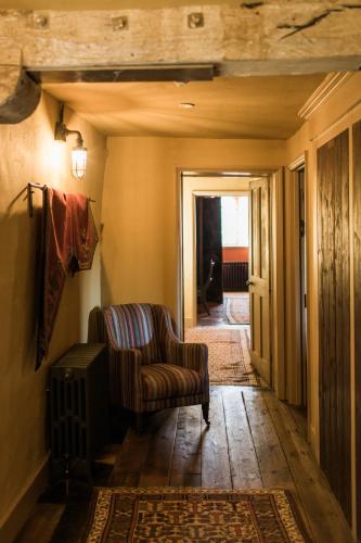 a living room with a chair and a hallway at St Giles House Accommodation in Wimborne Saint Giles