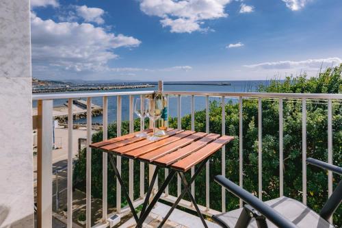 a balcony with a table and a view of the ocean at Appartamento Mare Blu in Sciacca