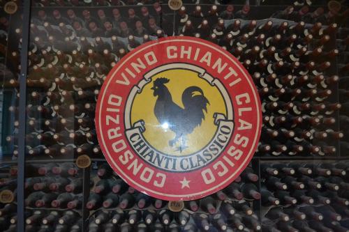 a sign in front of a wall of wine bottles at Terre di Melazzano - Le Case di Chiara in Greve in Chianti