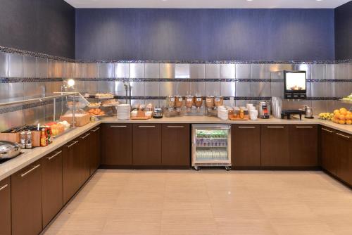 a large kitchen with brown cabinets and a food court at SpringHill Suites by Marriott Raleigh Cary in Cary