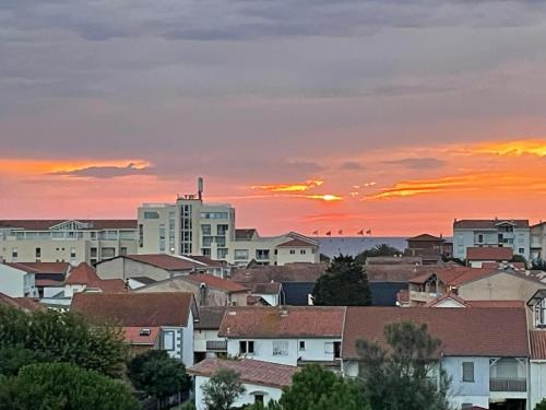 a city skyline with a sunset in the background at Holiday Home Sicard-3 by Interhome in Mimizan-Plage
