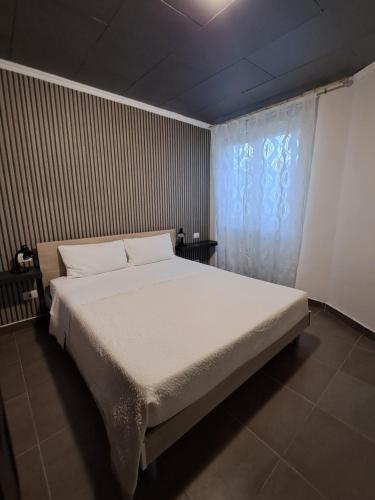 a bedroom with a large bed and a window at Corinna family in Casal Palocco