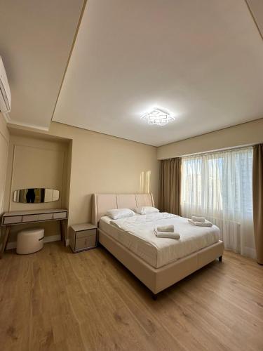 sypialnia z łóżkiem, stołem i oknem w obiekcie Prime Suites w mieście Biszkek