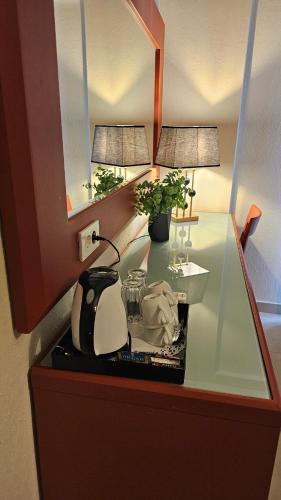 a glass table with a lamp and a tea kettle at Atlantis Boutique ΑΝΝΕX in Rhodes Town