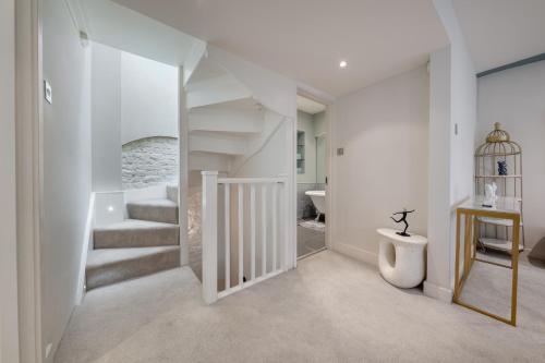 a white hallway with stairs and a bathroom at GRAND 200 SqM 3-Bedroom VILLA in London