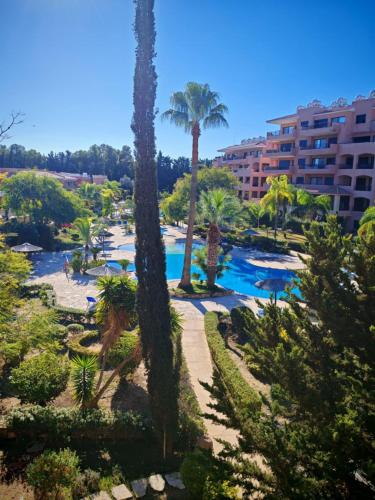 a view of a resort with palm trees and a pool at Aphrodite gardens 2 bedroom in Paphos City