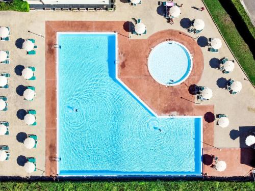 an overhead view of a swimming pool with tables and chairs at Apartment Santa Costanza-3 by Interhome in San Vincenzo