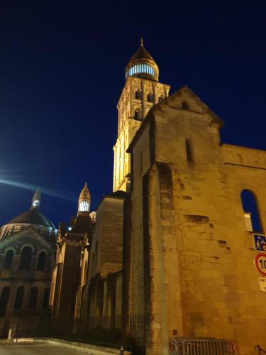 a building with a clock tower at night at Bristol Logis Cit'Hotel Périgueux Centre in Périgueux