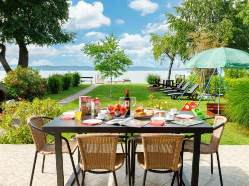 a black table with a breakfast of fruit and a playground at Holiday Home Hanna by Interhome in Balatonlelle